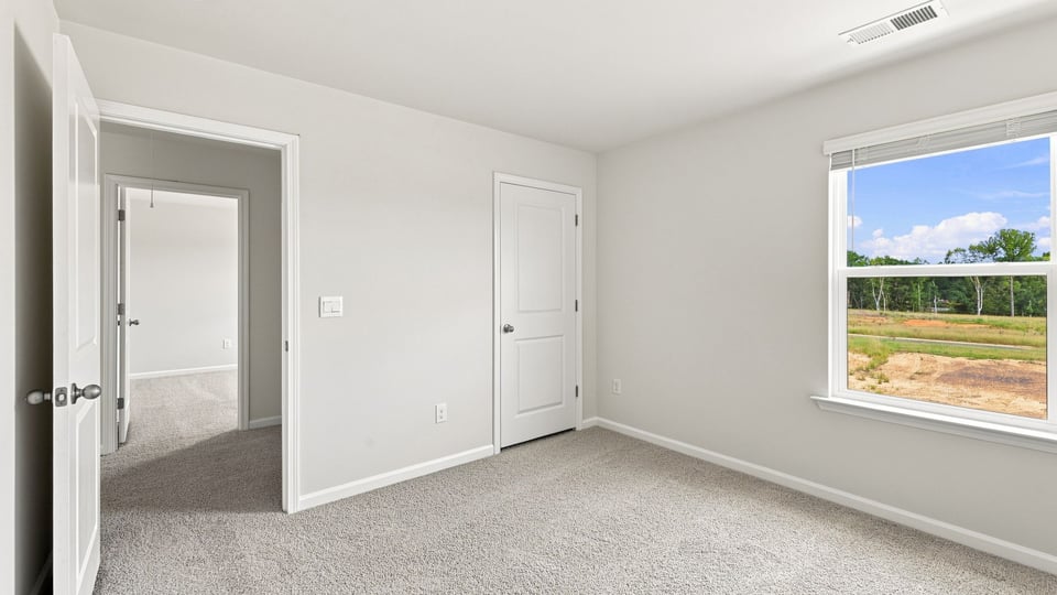 Bedroom with carpet and window.