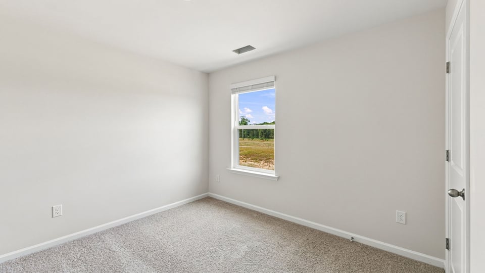 Bedroom with carpet and window.