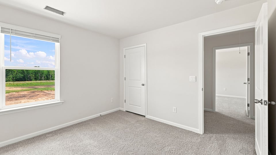 Bedroom with carpet and window.