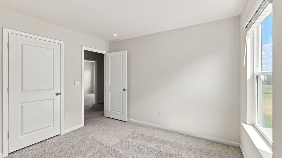 Bedroom with carpet and window.