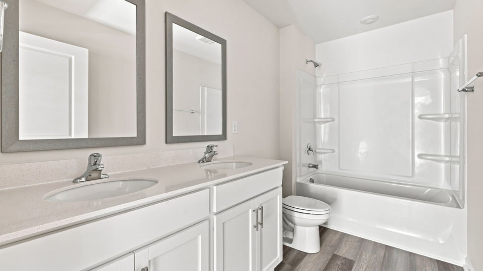 Bathroom with double vanity sink and bathtub.