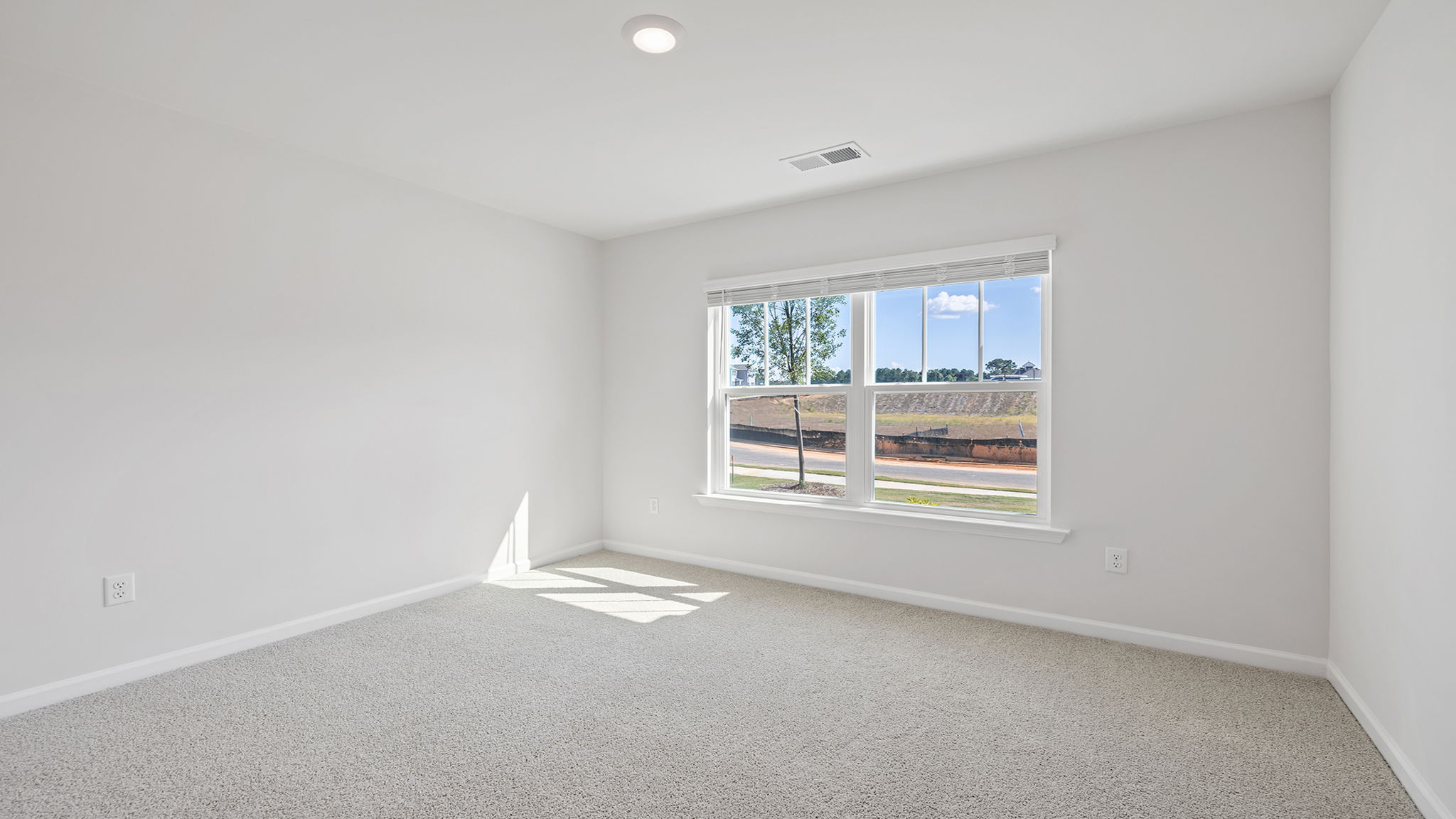 Bedroom with carpet and windows.