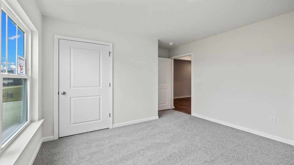 Bedroom with carpet and window.
