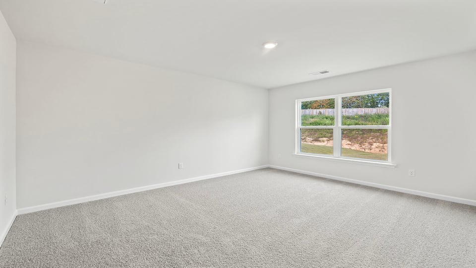 Bedroom with carpet and windows.