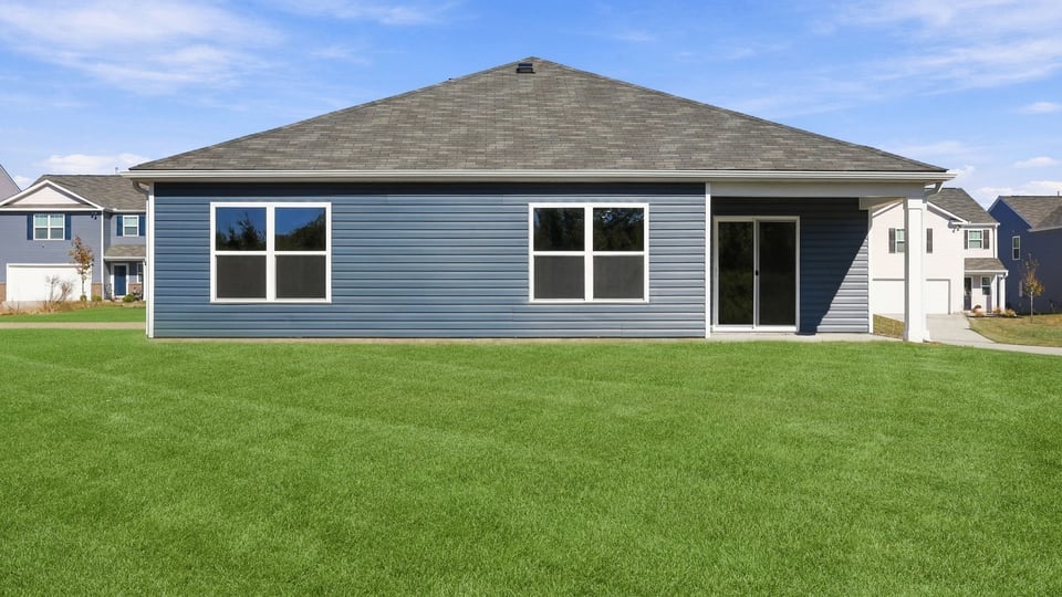 Back exterior of home with large backyard.