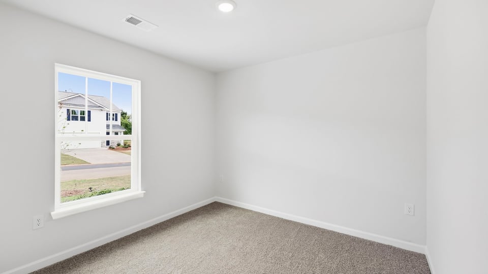 Bedroom with carpet and window.