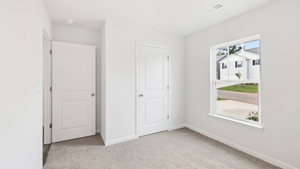 Bedroom with carpet and window.
