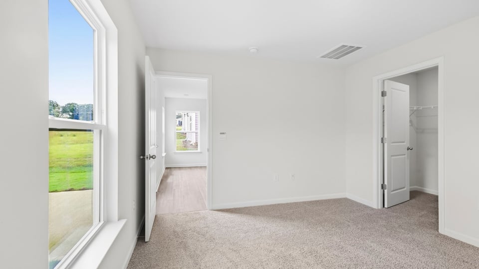 Bedroom with carpet and window.