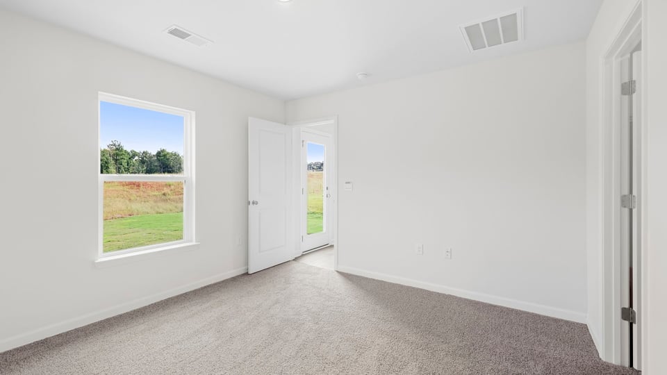 Bedroom with carpet and window.