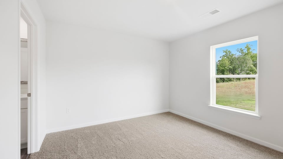 Bedroom with carpet and window.