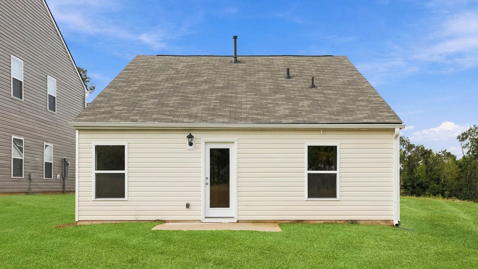 Back exterior of home with large backyard.