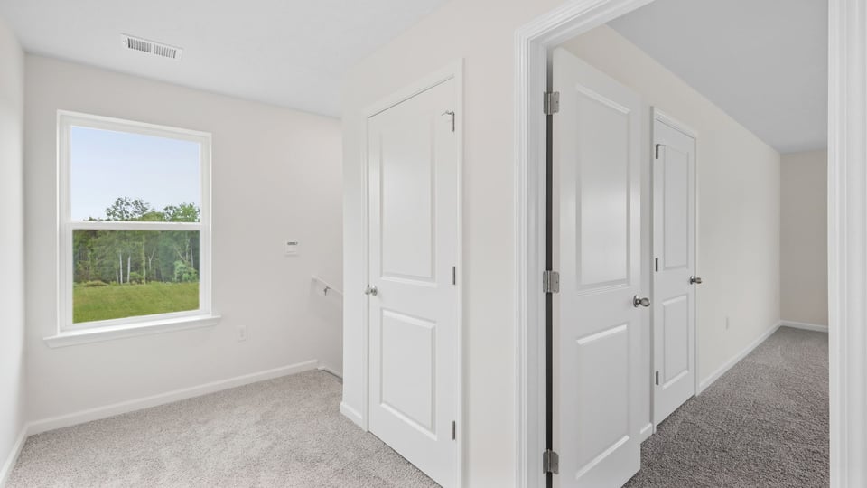 Loft area with carpet and window.