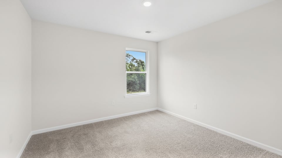 Bedroom with carpet and window.