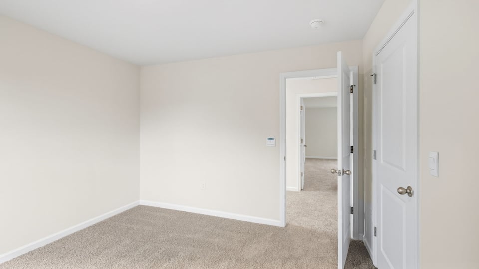 `Bedroom with carpet and window.