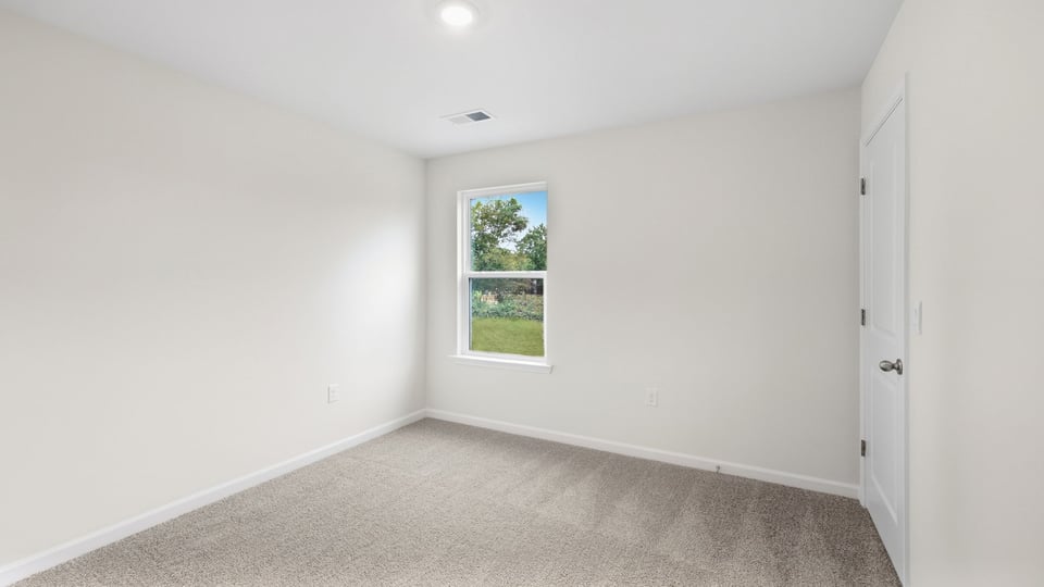 Bedroom with carpet and window.