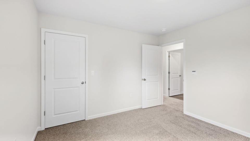 Bedroom with carpet and window.