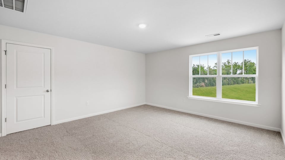 Bedroom with carpet and window.