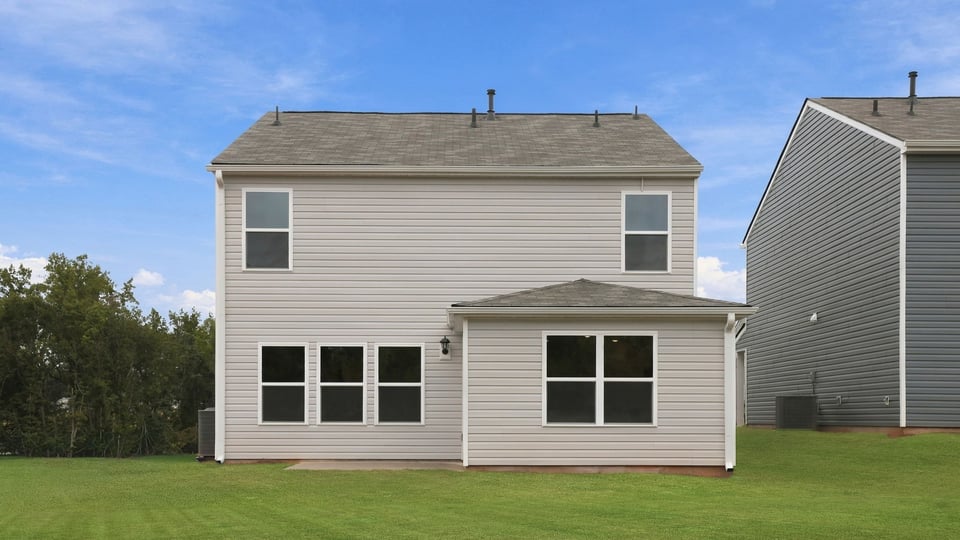 Back exterior of home with large backyard.