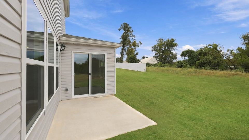 Back exterior of home with small patio.
