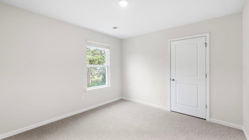 Bedroom with carpet and window.
