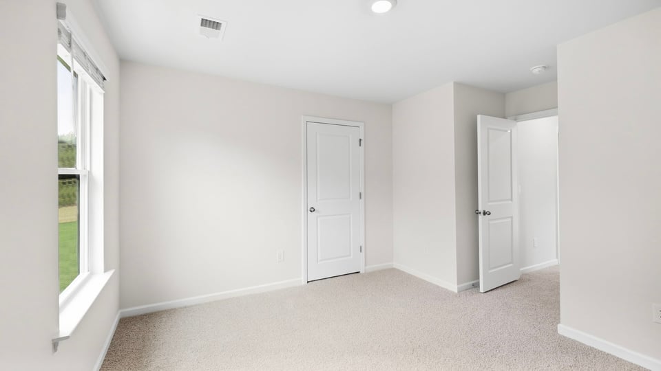 Bedroom with carpet and window.