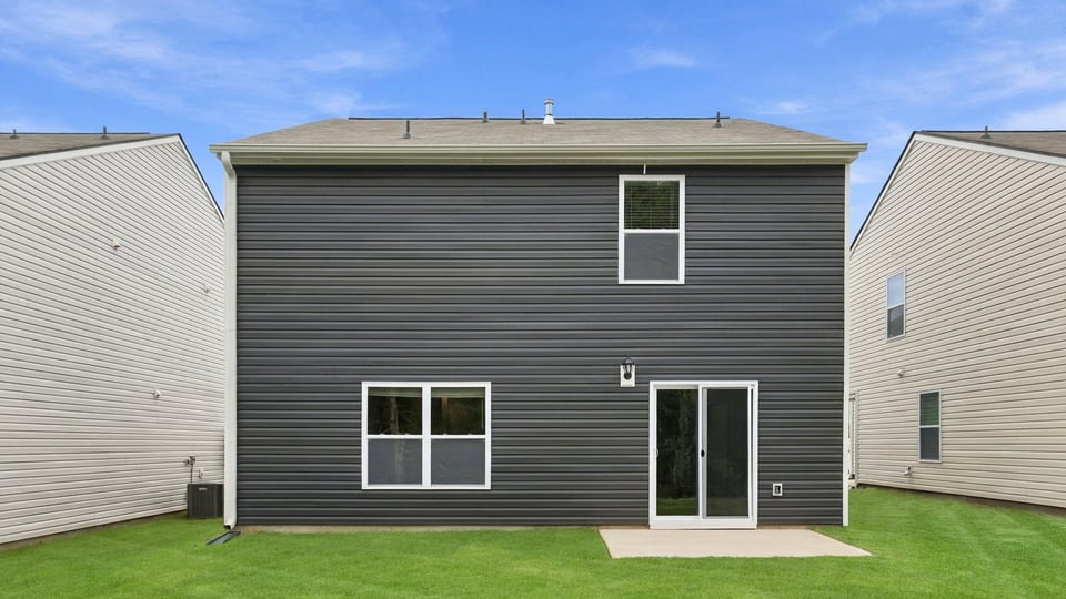 Back exterior of home with large backyard.
