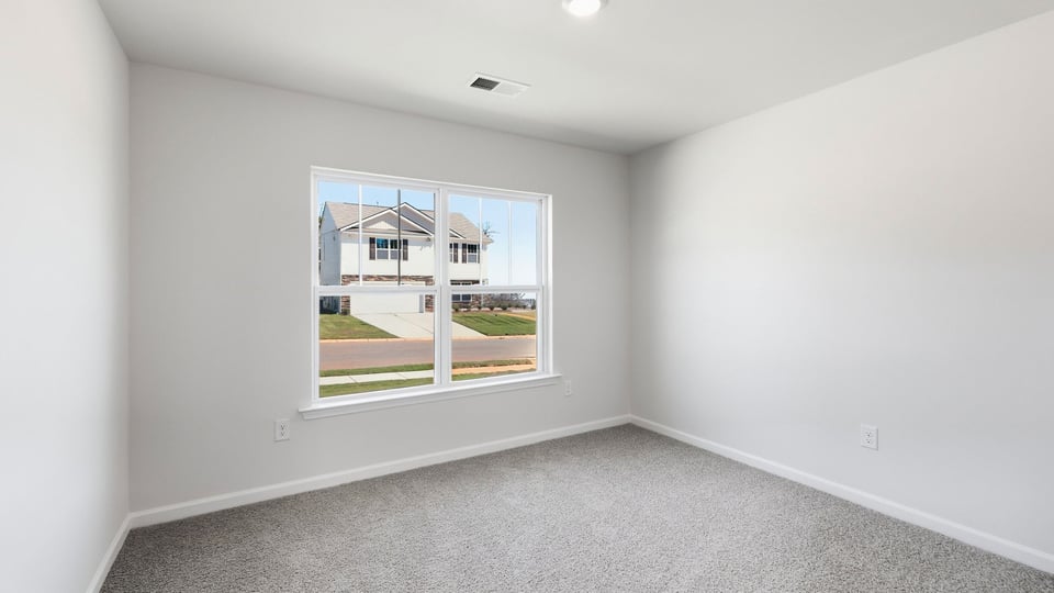Bedroom with carpet and window.