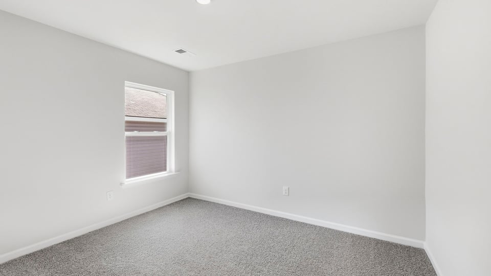 Bedroom with carpet and window.