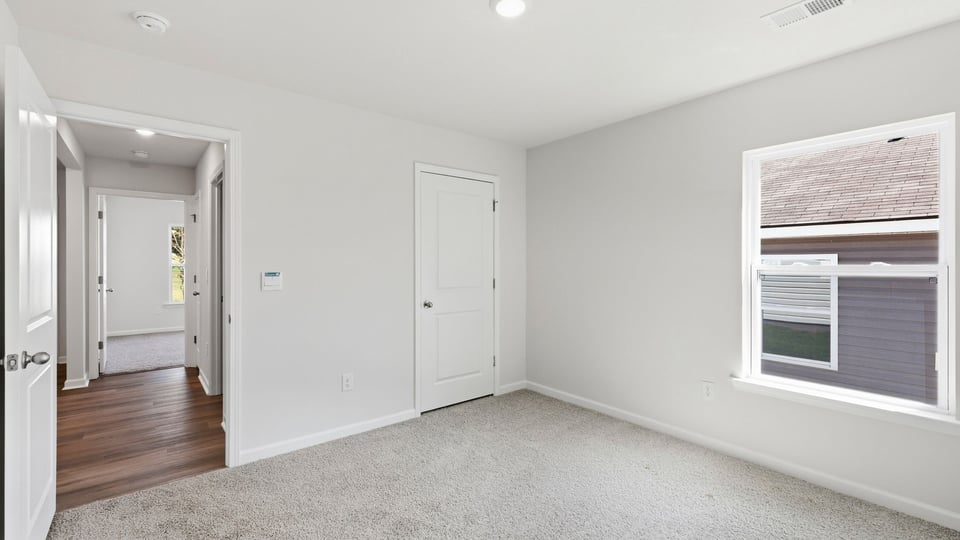 Bedroom with carpet and window.