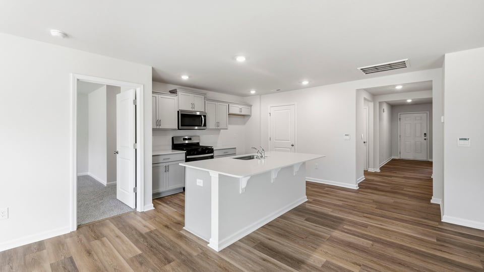 Kitchen and island and stainless steel appliances.