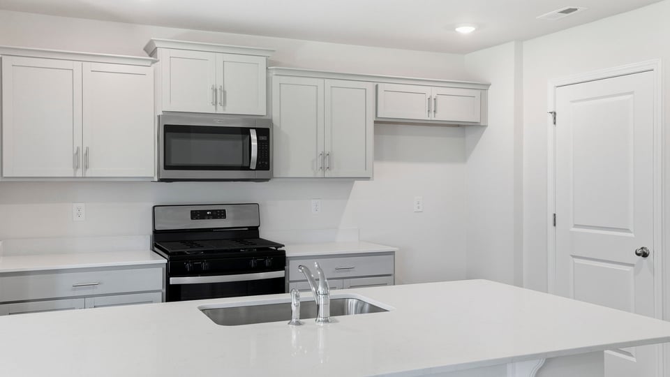 Kitchen and island and stainless steel appliances.