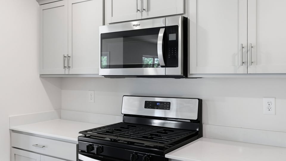 Kitchen and island and stainless steel appliances.