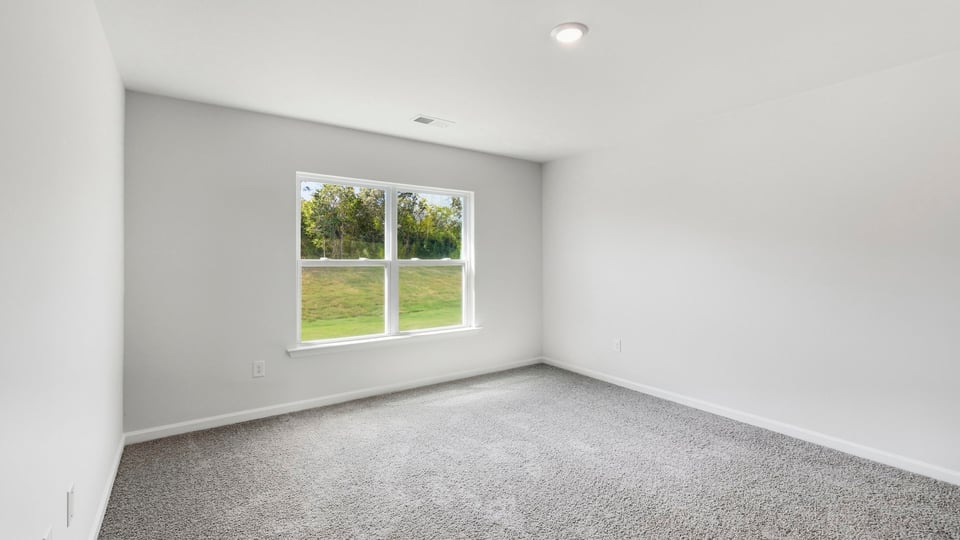 Bedroom with carpet and window.