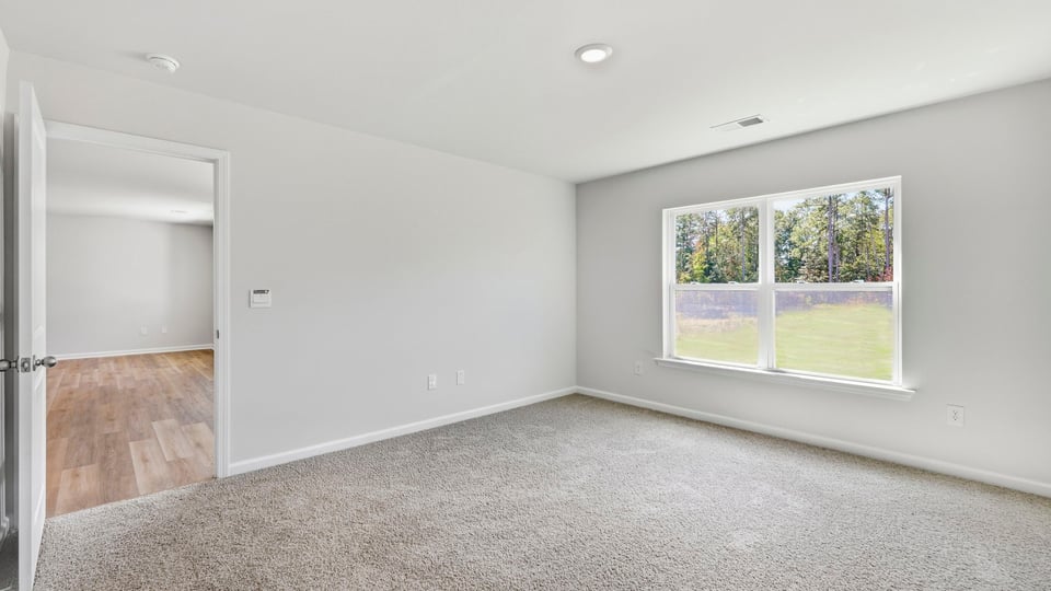 Bedroom with carpet and window.