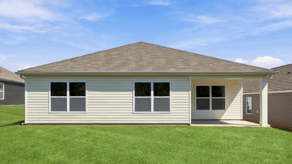 Back exterior of home with large backyard.