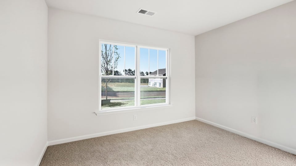 Bedroom with carpet and window.