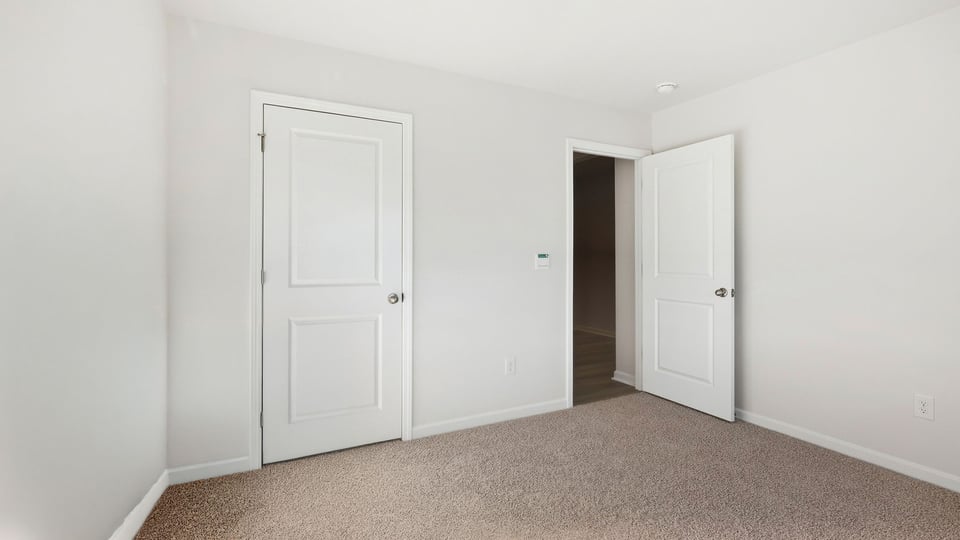 Bedroom with carpet and window.