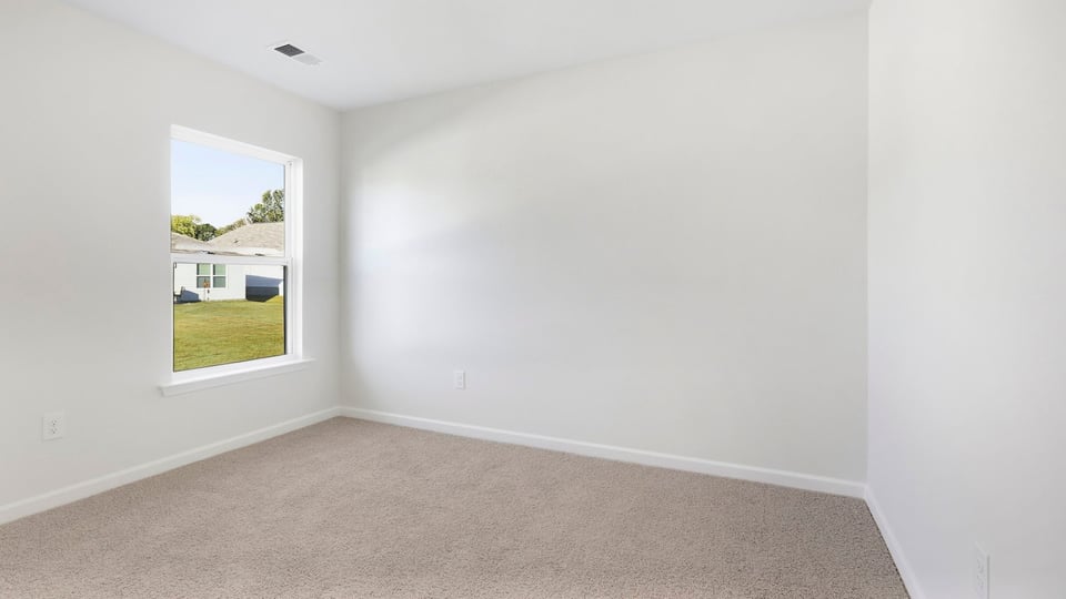 Bedroom with carpet and window.