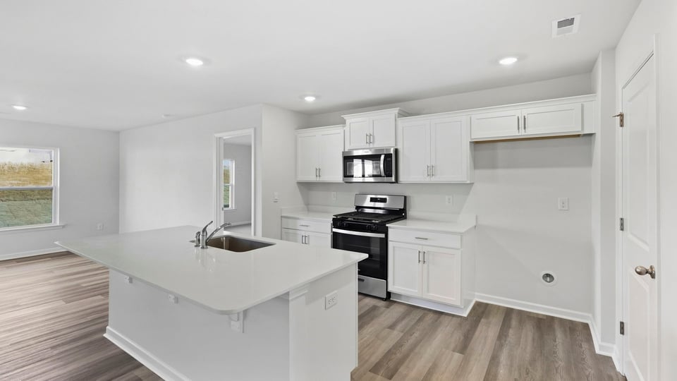Kitchen and island with quartz countertops.