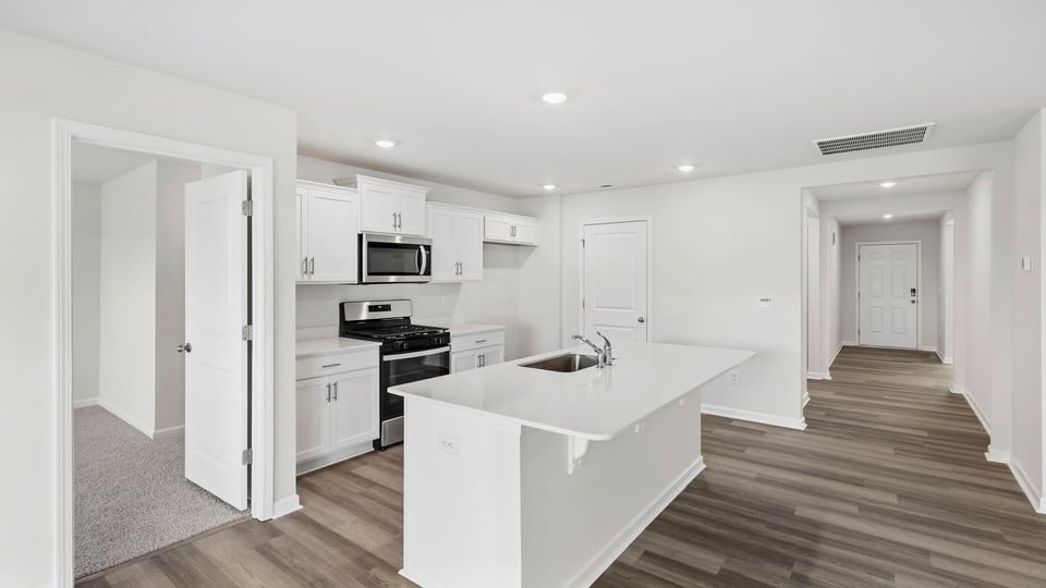 Kitchen and island with quartz countertops.
