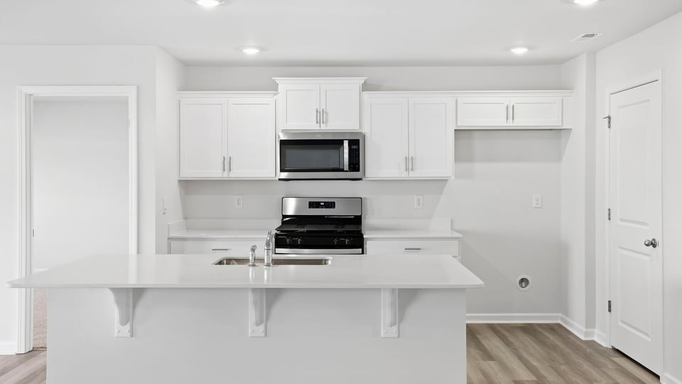 Kitchen and island with quartz countertops.