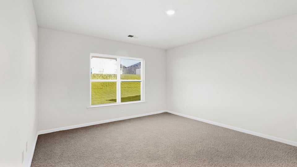 Bedroom with carpet and window.