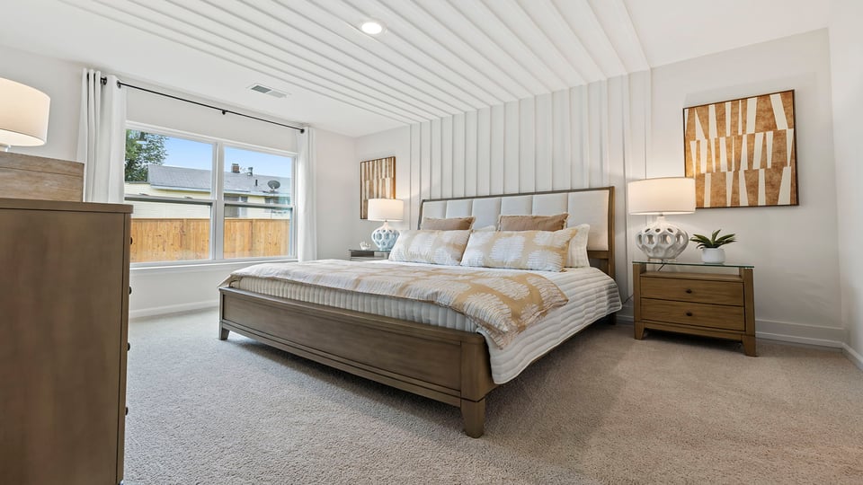 Primary bedroom with carpet and windows.