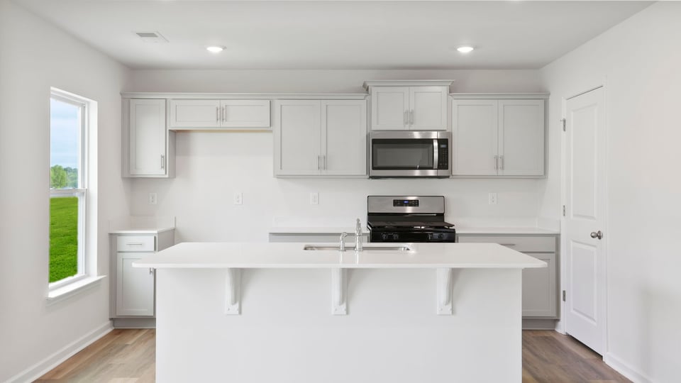 Kitchen and island with quartz countertops.