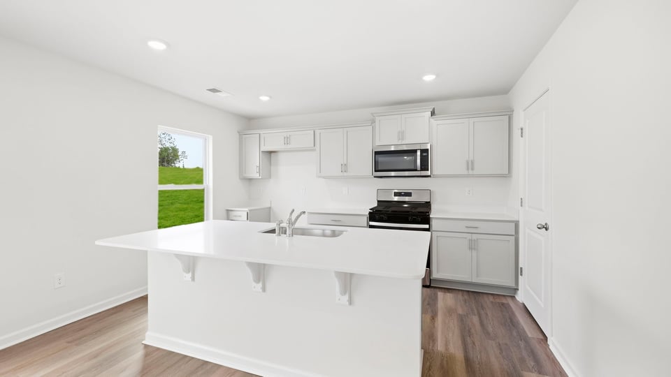Kitchen and island with quartz countertops.