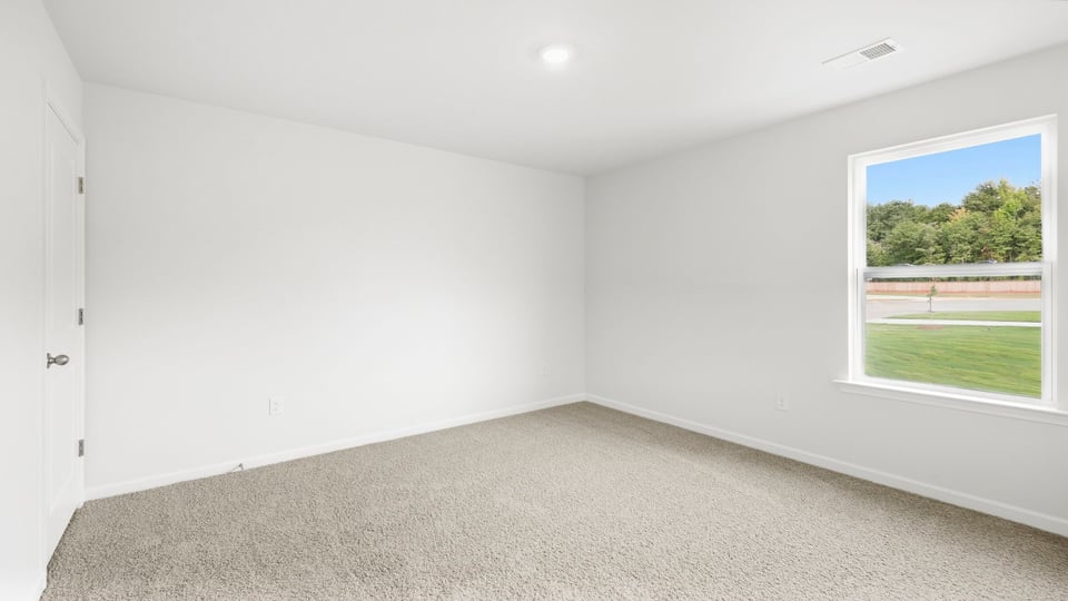 Bedroom with carpet and windows.