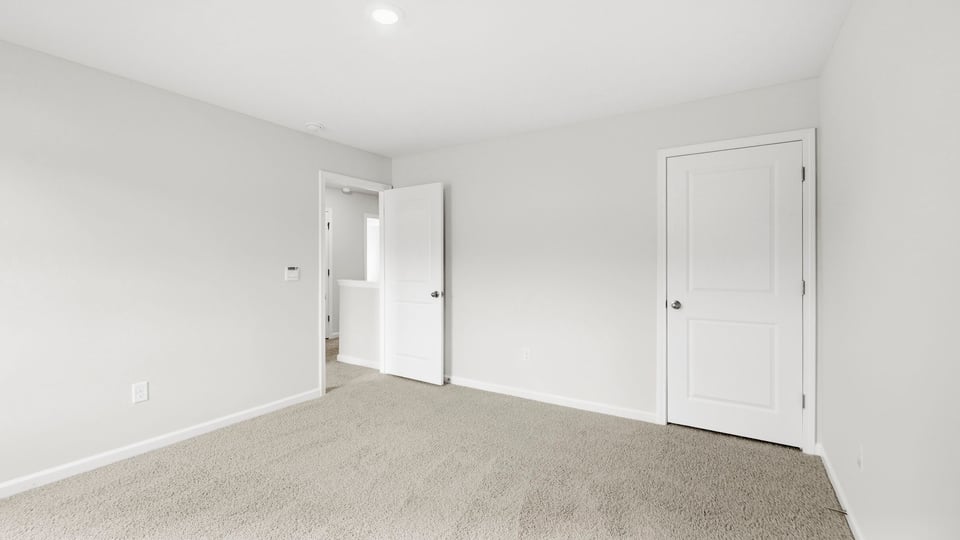 Bedroom with carpet and windows.