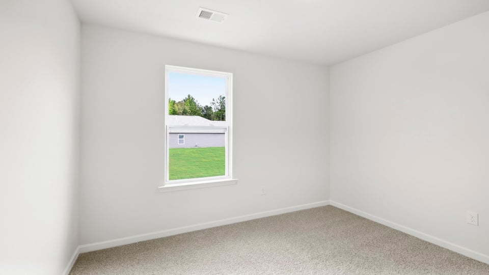 Bedroom with carpet and windows.
