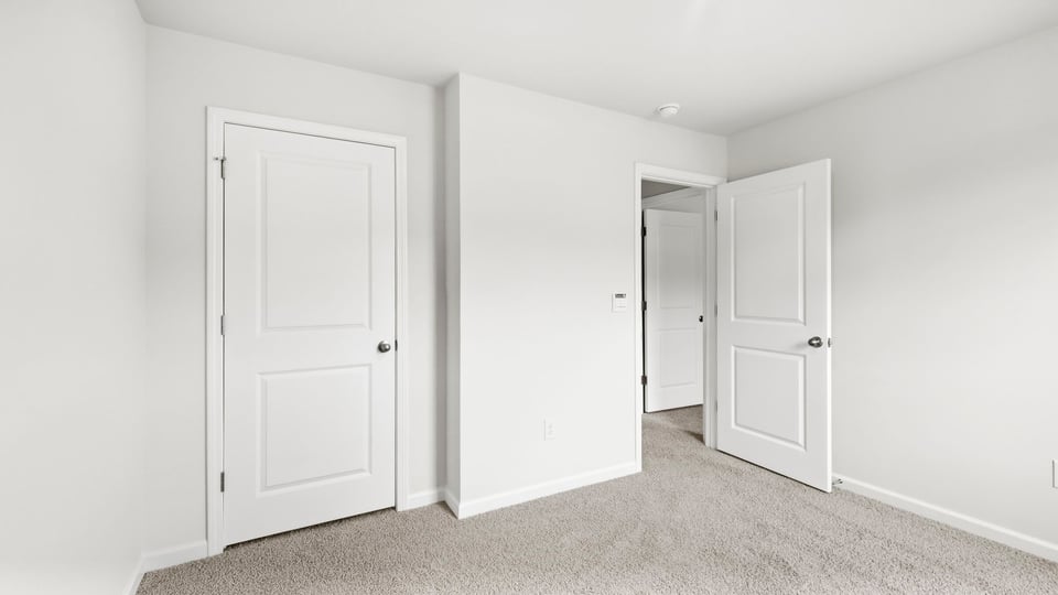 Bedroom with carpet and windows.