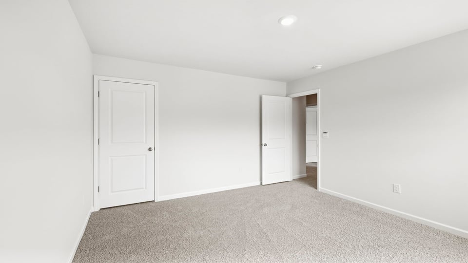 Bedroom with carpet and windows.
